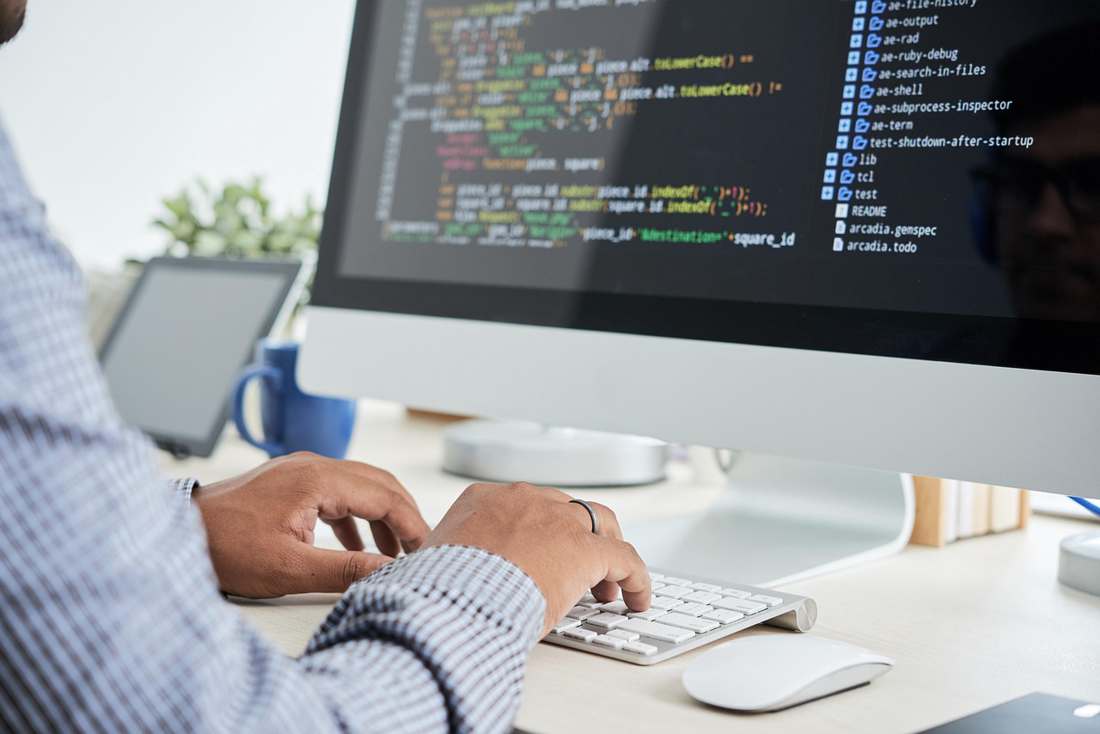 Professores em sala de aula utilizando computadores com ajuda de inteligência artificial